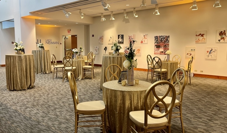 Art gallery with track lighting and small tables set up for an event