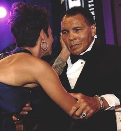 Halle Berry touching Muhammad Ali's face while he holds her arm