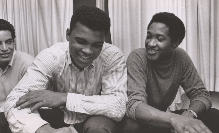 Black and white photo of Muhammad Ali and Sam Cooke seated next to each other