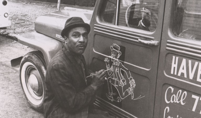Black and white photo of Ali's father, Cassius Clay Sr., painting on van door