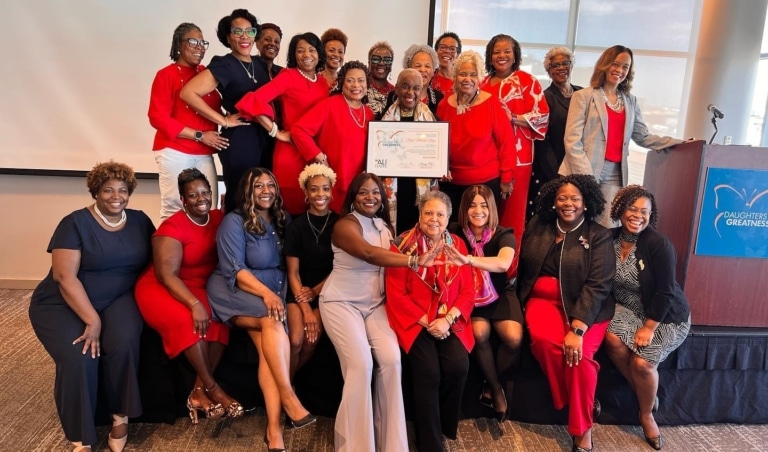 A group of women all dressed in red posing with an award