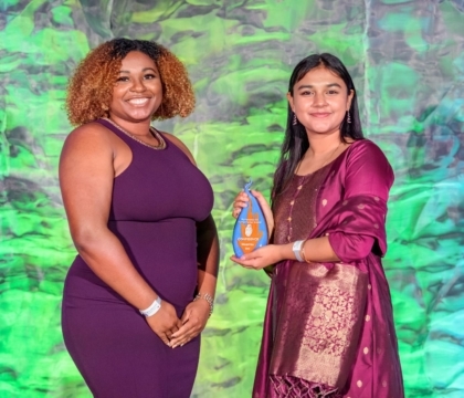 Two women posing with an award