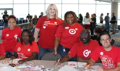 A group of Target employees in red shirts at the Ali Center at a table with crafts