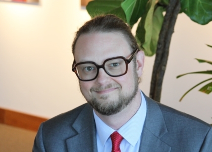 Man with glasses and a beard in a suit