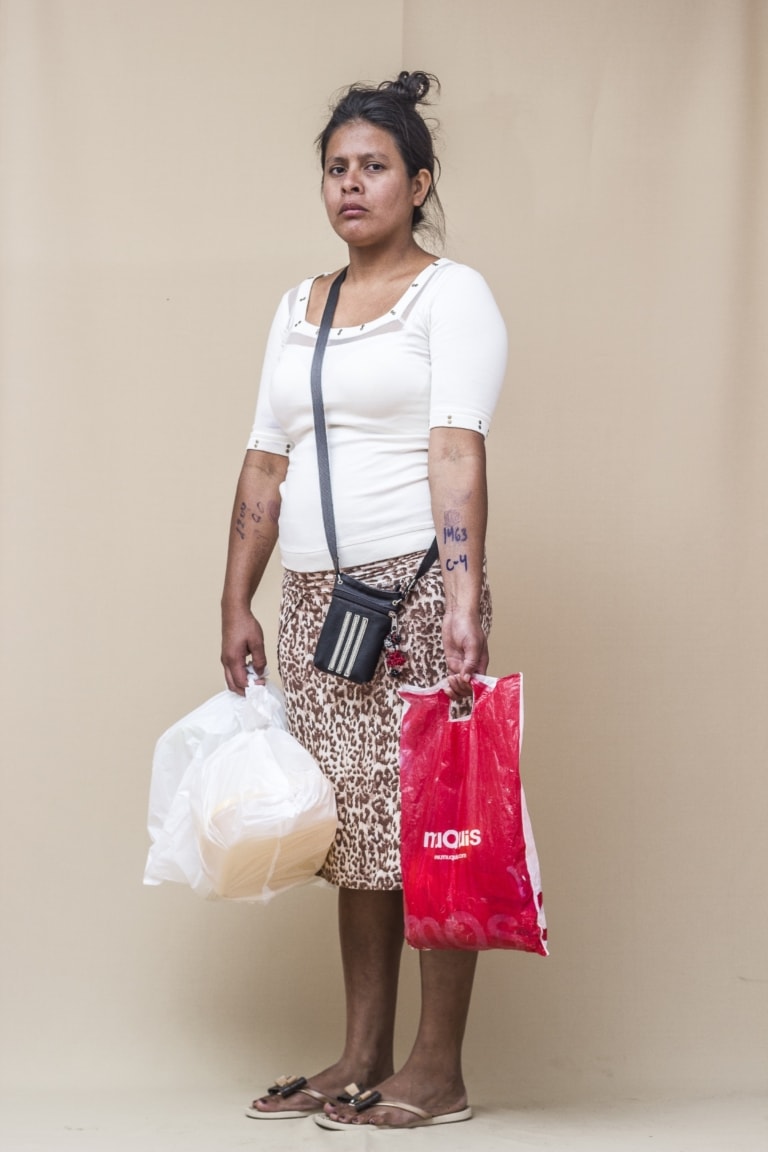 Woman standing with plastic bags and a small purse