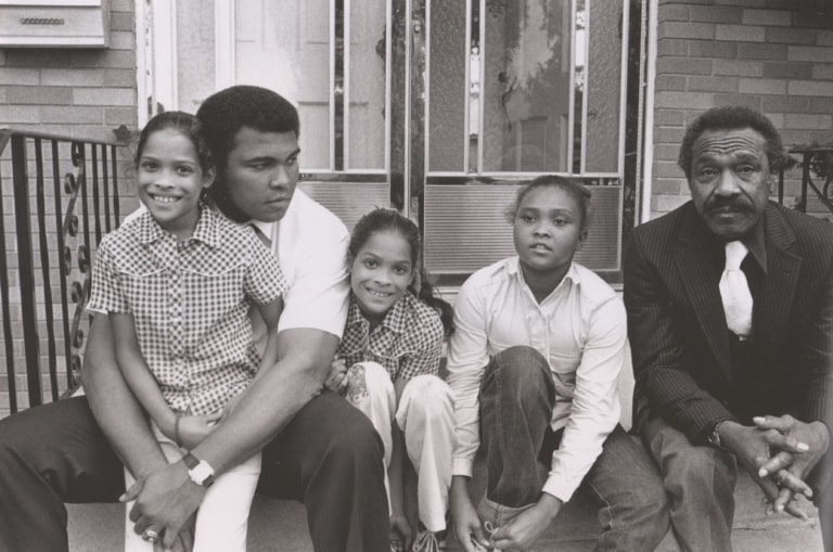 Black and white photo of Muhammad Ali with his father and daughters Rasheeda, Jamillah, and Maryum