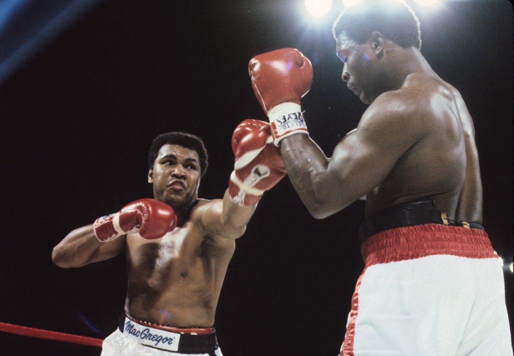 Action photo of Muhammad Ali throwing punch toward Trevor Berbick in the ring