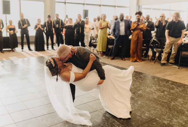 Man kisses woman in wedding dress as crowd cheers