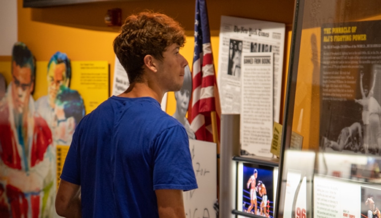 Teenager looking at Muhammad Ali Center exhibit