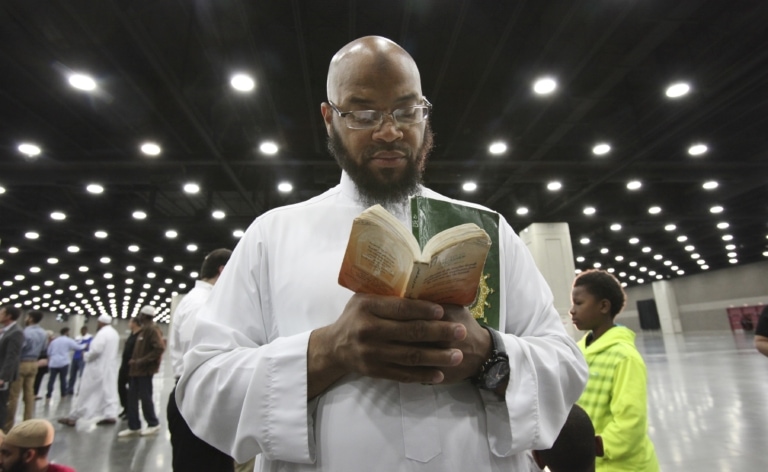 Sayfullaah Ali reads from a collection of Muslim prayers before the Janazah for Muhammad Ali at Freedom Hall