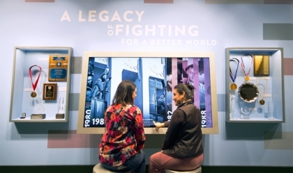 Two women looking through exhibit showcasing Ali's timeline