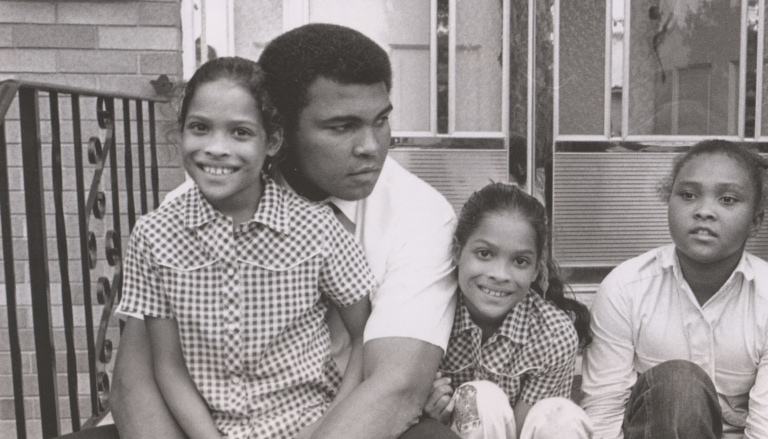 Black and white photo of Muhammad Ali with his father and daughters Rasheeda, Jamillah, and Maryum
