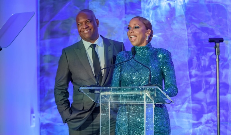 Holly Robinson Peete and Rodney Peete at podium with blue background