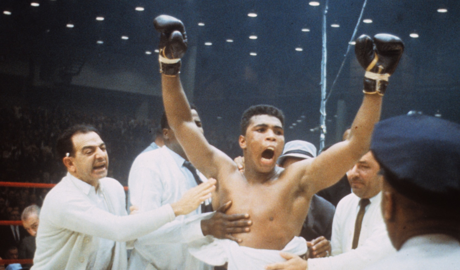 Photo of Muhammad Ali celebrating with gloves in the air