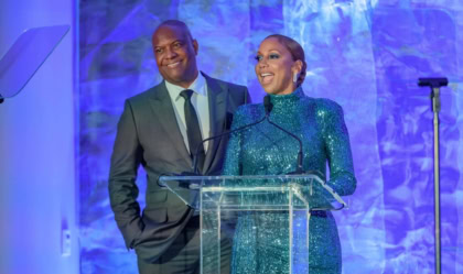 Holly Robinson Peete and Rodney Peete at podium with blue background