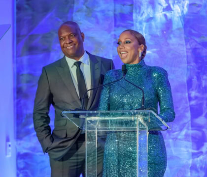 Holly Robinson Peete and Rodney Peete at podium with blue background