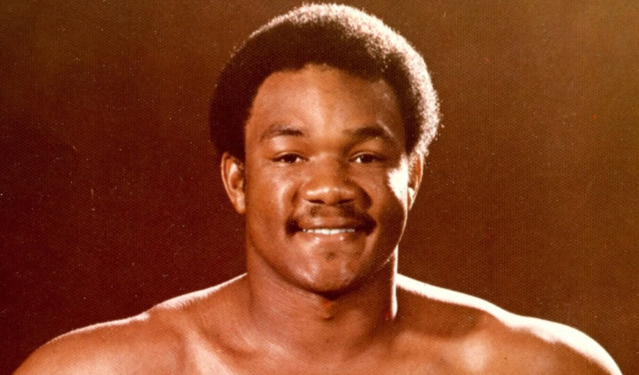 Image of green Christmas card featuring photo of George Foreman in boxing attire with text "Wishing you a Happy Christmas and a Bright New Year"