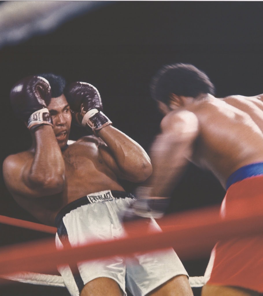 Color photo of Muhammad Ali dodging punch from George Foreman in boxing ring