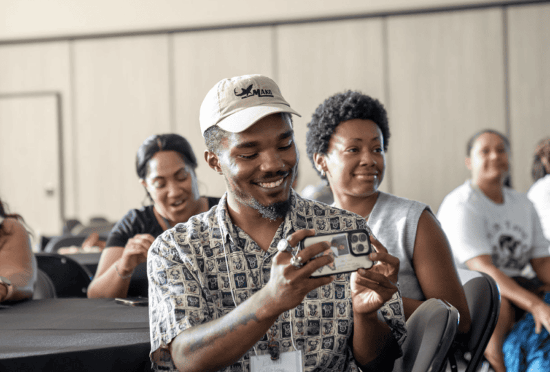 Man sitting at table taking a photo with his phone