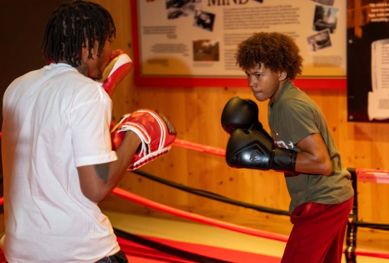 Photo of two teenagers within boxing ring with boxing poses