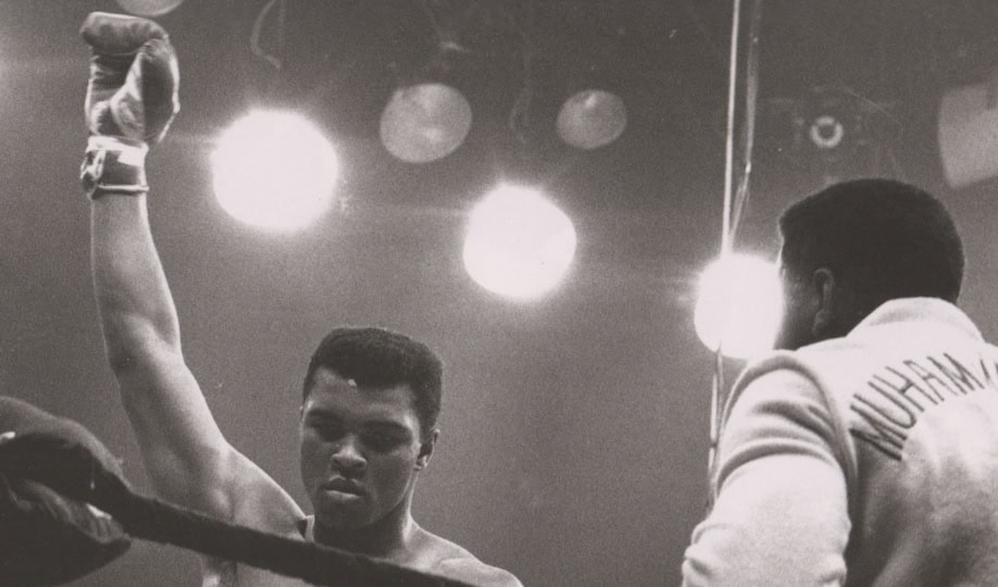 Black and white photo of Muhammad Ali in a boxing ring victorious