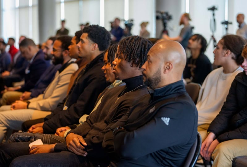 Audience members sitting in seats looking off camera