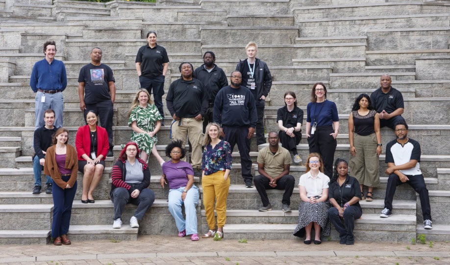 A group of people sit and stand on stairs
