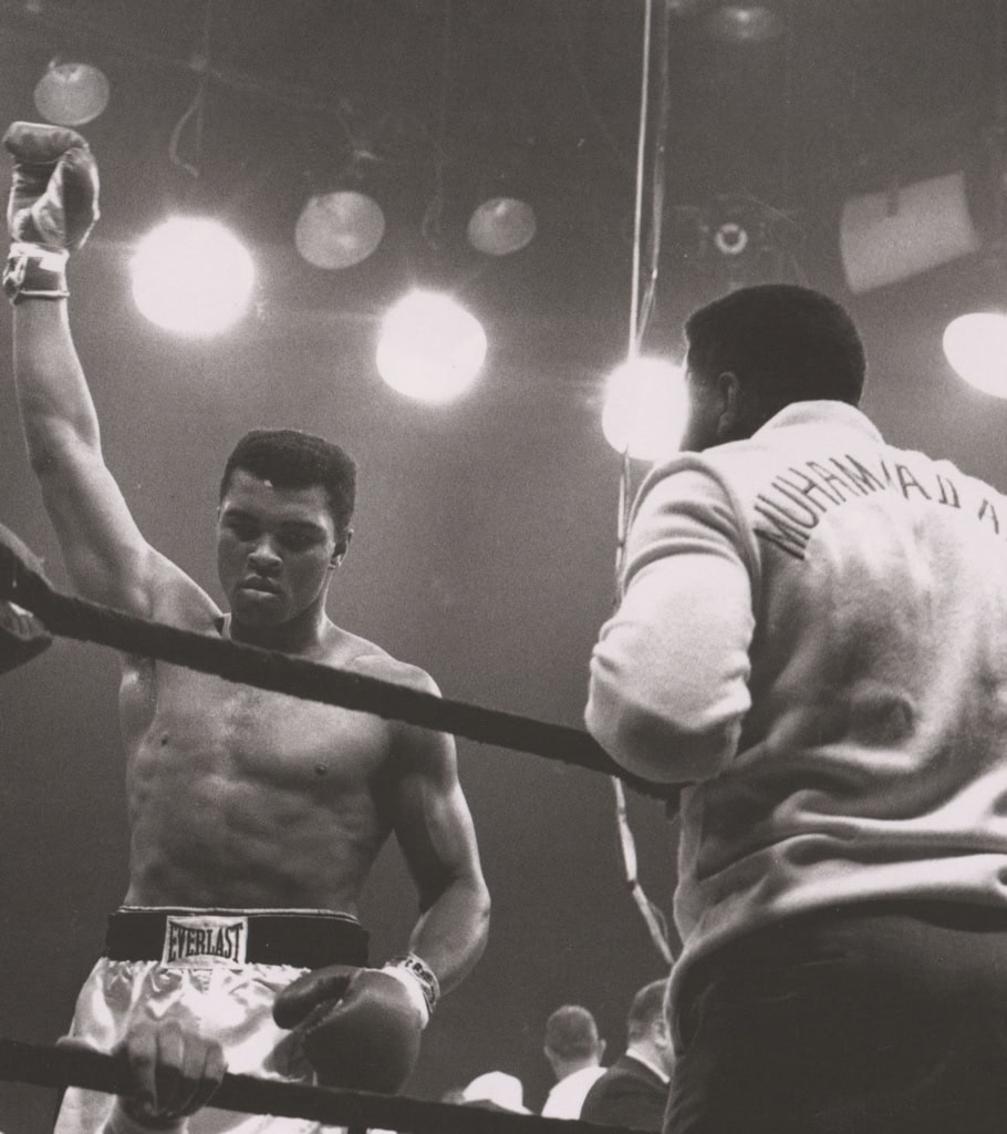 Black and white photo of Muhammad Ali in a boxing ring victorious