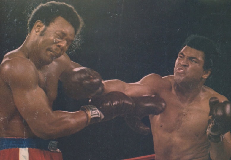 Photo of Sports Illustrated cover with image of Muhammad Ali and George Foreman in boxing ring with Ali throwing punch at Foreman
