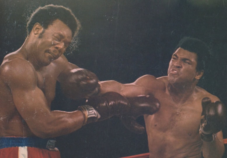 Photo of Sports Illustrated cover with image of Muhammad Ali and George Foreman in boxing ring with Ali throwing punch at Foreman