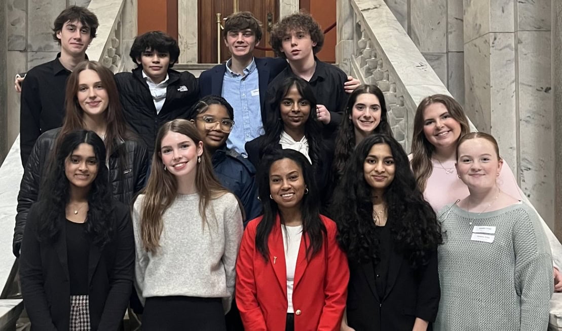 Photo of high school students on the steps of the Kentucky State Capitol smiling at camera