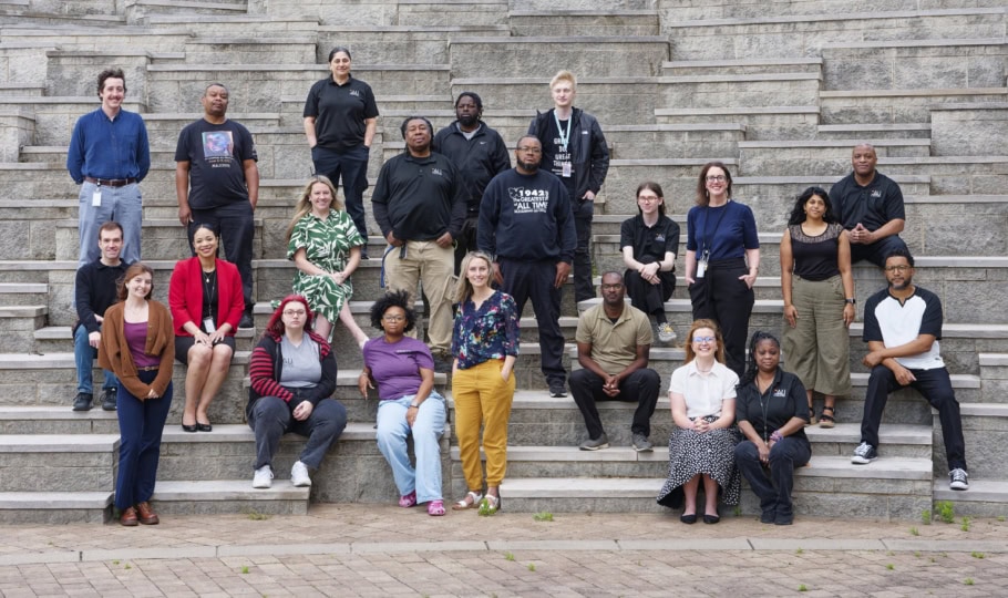 A group of people sit and stand on stairs