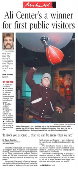 Newspaper clipping featuring young boy in burgundy jacket hitting speedbag with caption "Ali Center's a winner for first public visitors"