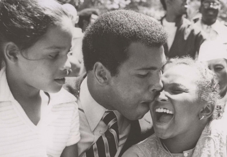 Black and white photo of Muhammad ALi with his daughters, Rasheeda and Maryum