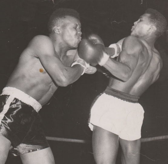 Black and white photo of Muhammad Ali dodging in a boxing ring