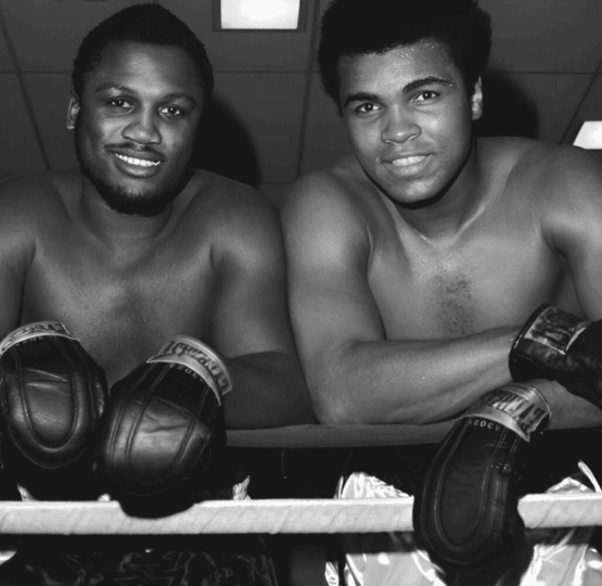 Black and white photo of Frazier and Ali leaning against boxing ropes