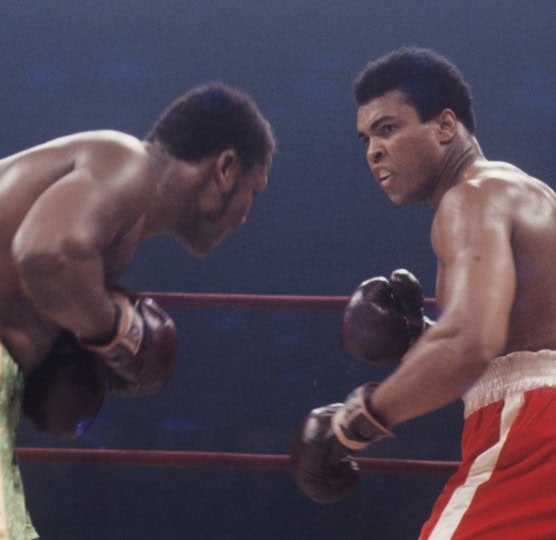 Action photo of Muhammad Ali and Joe Frazier during boxing match