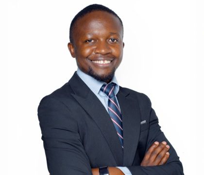 Man smiling with arms crossed wearing dark suit
