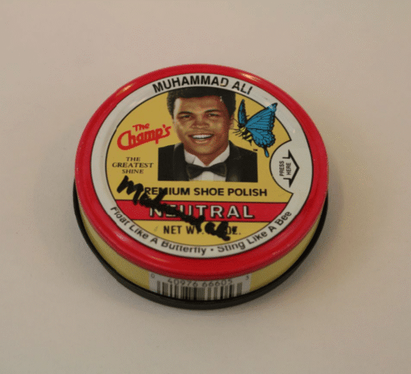 Red and yellow can of shoe polish with Muhammad's image and an illustrated bee with butterfly wings, signed by Muhammad Ali