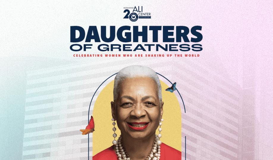 Photo of woman with short white hair wearing red top smiling placed on Ali Center backdrop with Daughters of Greatness logo