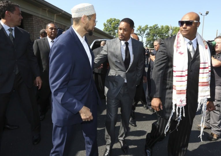 Men standing outside funeral home wearing suits and ties