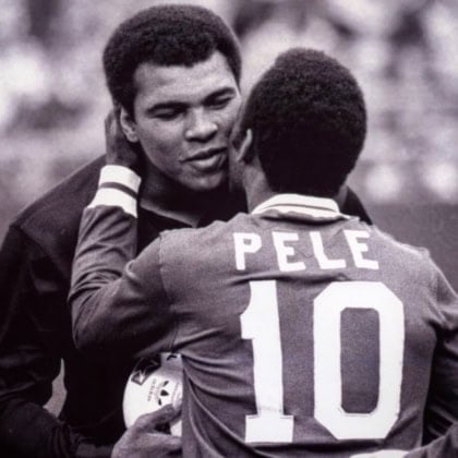 Muhammad Ali leaning in for a hug with Pele, who is wearing his #10 jersey