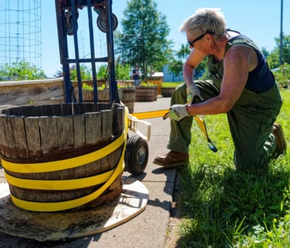 person tying bucket to dolly while grinning