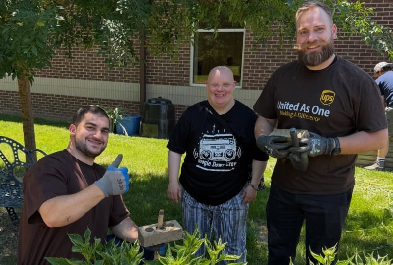 Group of people standing outside in garden and posing for camera