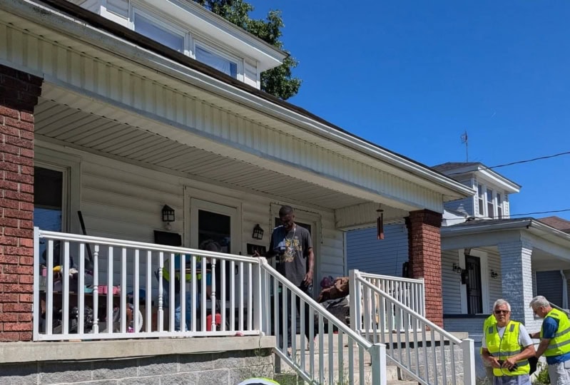 People outside of a home doing construction work