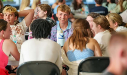 Students sitting and smiling around a table