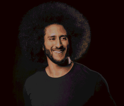 Photo of Colin Kaepernick wearing blue sweater looking off camera and smiling
