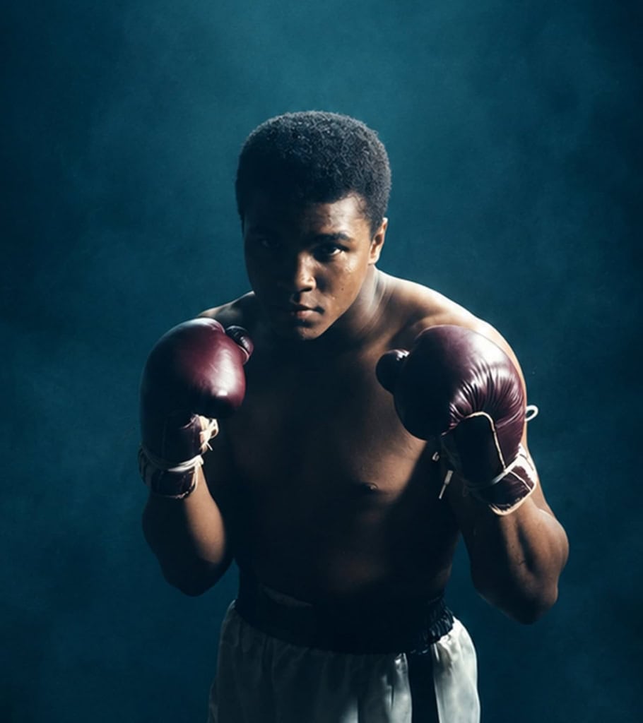 Photo of Muhammad Ali facing forward in blue smog-filled background