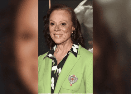 Photo of Lonnie Ali wearing green jacket smiling at camera